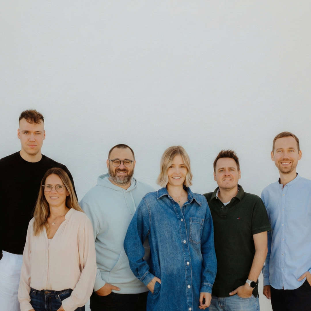 Frontalansicht von 2 Herren und einer Dame in selbstbewusster Pose